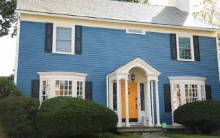 Blue two-story colonial home with white trim and a bright yellow front door in Annapolis MD