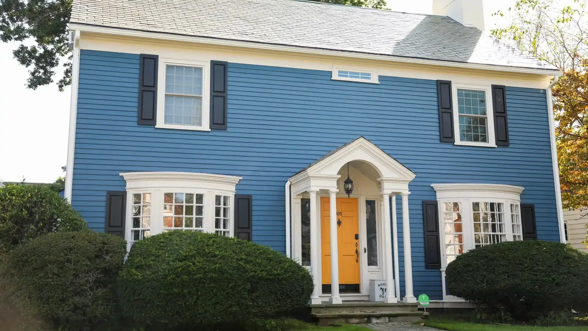 Blue two-story colonial home with white trim and a bright yellow front door in Annapolis MD