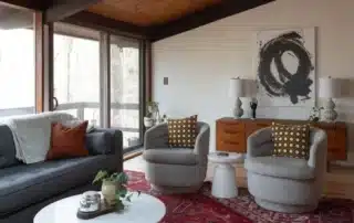 Mid-century modern living room with gray sofa, swiveling armchairs, and fresh interior paint in Annapolis MD