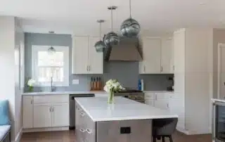 Modern kitchen with white cabinets, blue accent wall, and a large island