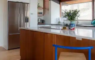 Modern kitchen featuring warm wood kitchen island and white upper cabinets