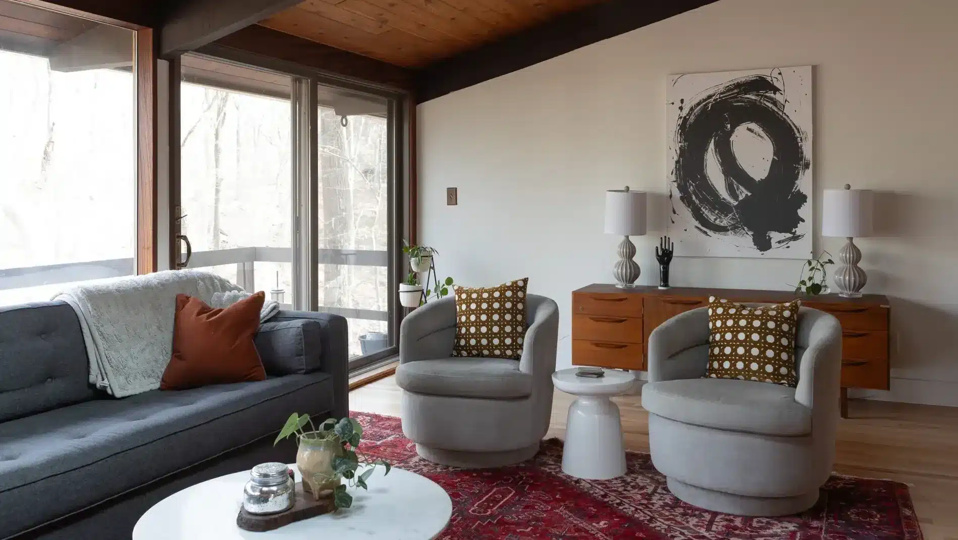 Mid-century modern living room with gray sofa, swiveling armchairs, and fresh interior paint