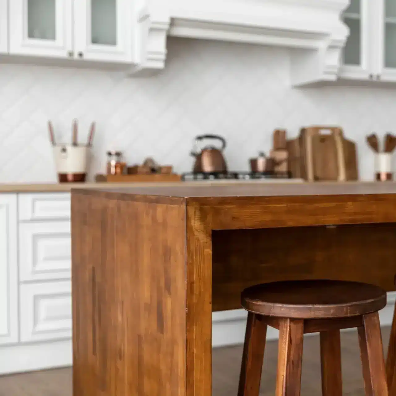 Freshly refinished wooden kitchen island and white cabinets by BluePeake Painting