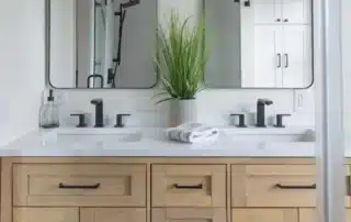 Light wood double vanity with black hardware and white countertops