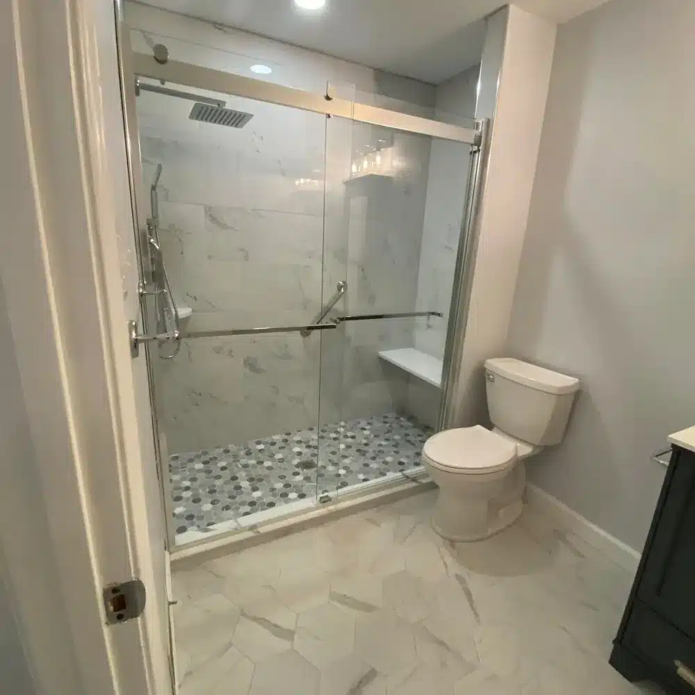 Bathrooms Modern Glass Shower Annapolis Md Modern bathroom with white hexagonal floor tiles, glass shower enclosure, and white toilet
