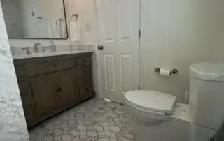 Bathrooms Modern Wood Vanity Annapolis Md Modern residential bathroom with dark wood vanity, white toilet, and patterned tile floor