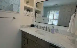 Cabinet Refinishing Grey Vanity Annapolis Md Grey wooden vanity with marble countertop and modern black-framed mirror in a bright bathroom
