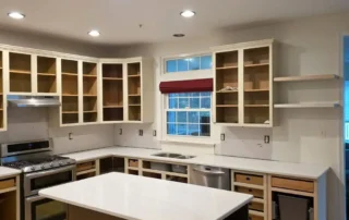 Unfinished kitchen cabinets and island undergoing cabinet refinishing work