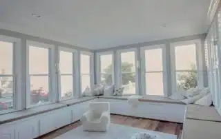 Built-in white window bench seating with storage cabinets and cushions