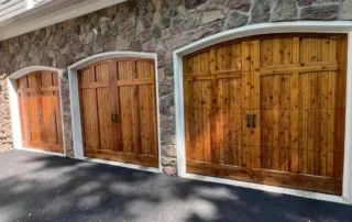 Three arched wooden garage doors on a stone facade home in Annapolis MD