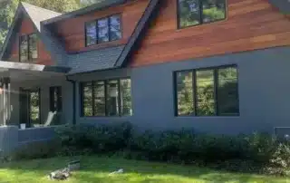 Modern house exterior with dark gray paint and warm wood siding