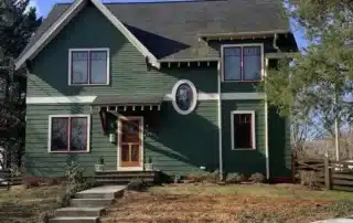 Green two-story house with white trim and dark roof in Annapolis MD