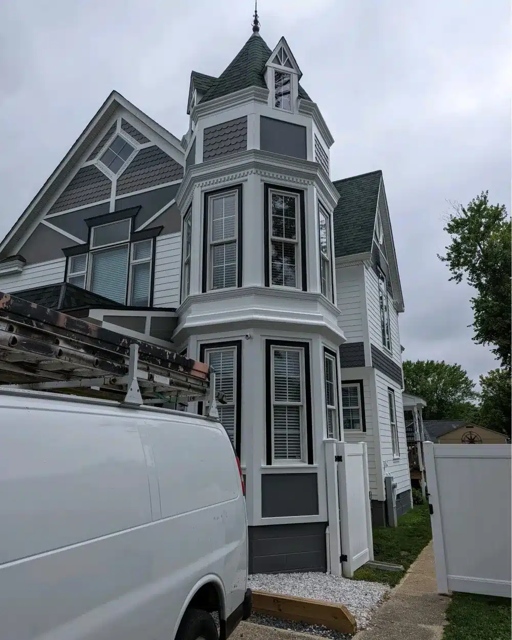 Exterior Painting Victorian House Annapolis Md Victorian style home with white siding, dark grey trim, and corner turret undergoing exterior painting in Annapolis MD