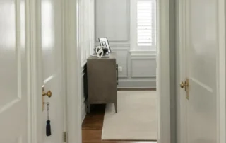 White panel doors and trim framing a grey hallway with dark hardwood floors