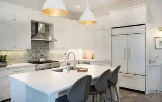Bright white kitchen with custom cabinets, gold hardware, and large island