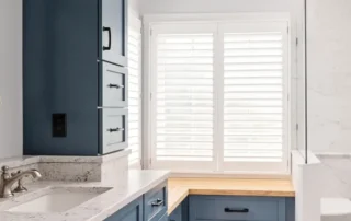Blue vanity cabinets with granite countertop and yellow flowers in Annapolis bathroom