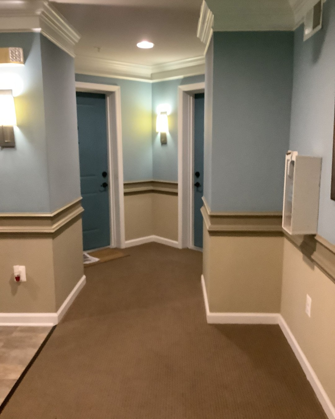 Hallway interior painted with blue upper walls and tan wainscoting