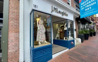Storefront of J.McLaughlin retail shop with blue trim and brick facade in Annapolis Md