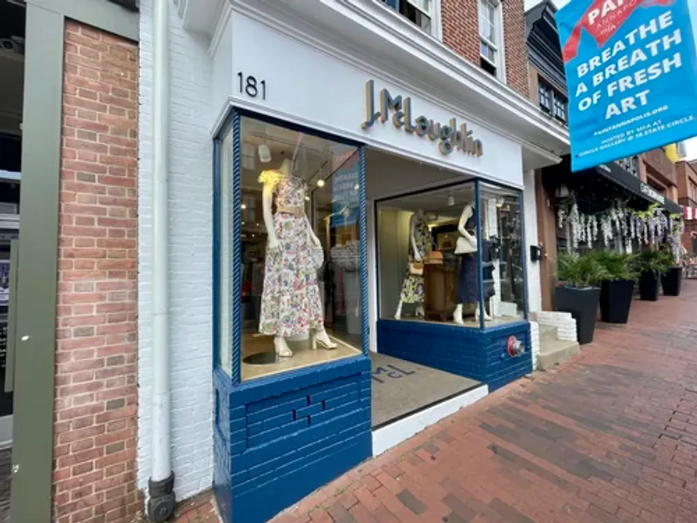 Storefront of J.McLaughlin retail shop with blue trim and brick facade in Annapolis Md