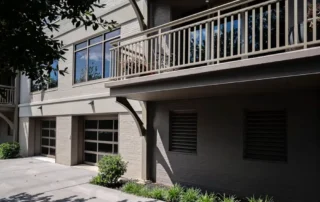 Exterior painting on a multi-story residential building with a balcony and garage