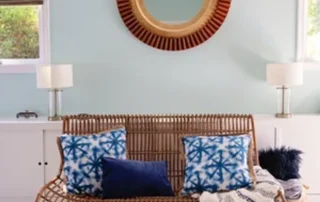 Interior Painting Light Blue Walls Rattan Sofa Annapolis Md Living room with light blue walls, rattan sofa, patterned pillows, and a round mirror