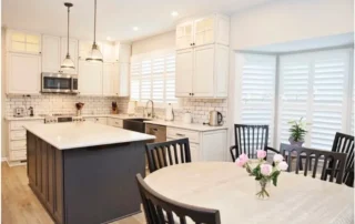 White kitchen with dark island and dining table