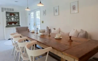 Residential Dining Room Interior Painting Annapolis Md Long wooden dining table with white chairs and bench seating in bright Annapolis dining room