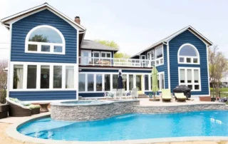 Blue two-story residential house with white trim, deck, and in-ground swimming pool in Annapolis Md