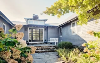 Grey shingle home exterior with white trim and dark front door in Annapolis