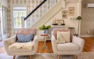 Blue-Star-006 Sitting area with cream armchairs beside a staircase with floral wallpaper