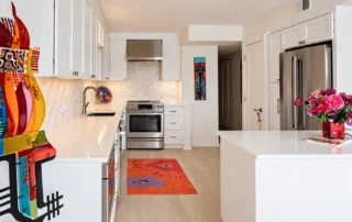 White shaker kitchen cabinets with stainless steel appliances, white countertops, and a subway tile backsplash