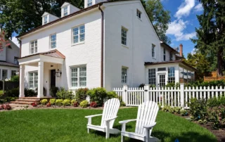 white-brick-house-picket-fence White painted brick house with a picket fence and landscaped lawn